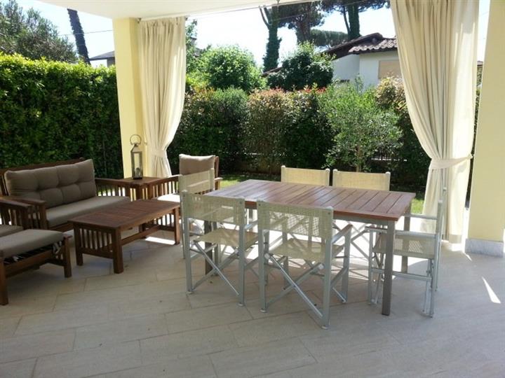 veranda attrezzata con salotto e zona pranzo